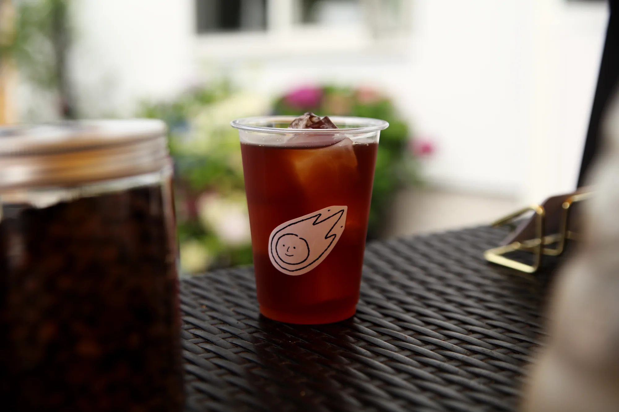 木のテーブルに置かれた Comet のアイスコーヒー