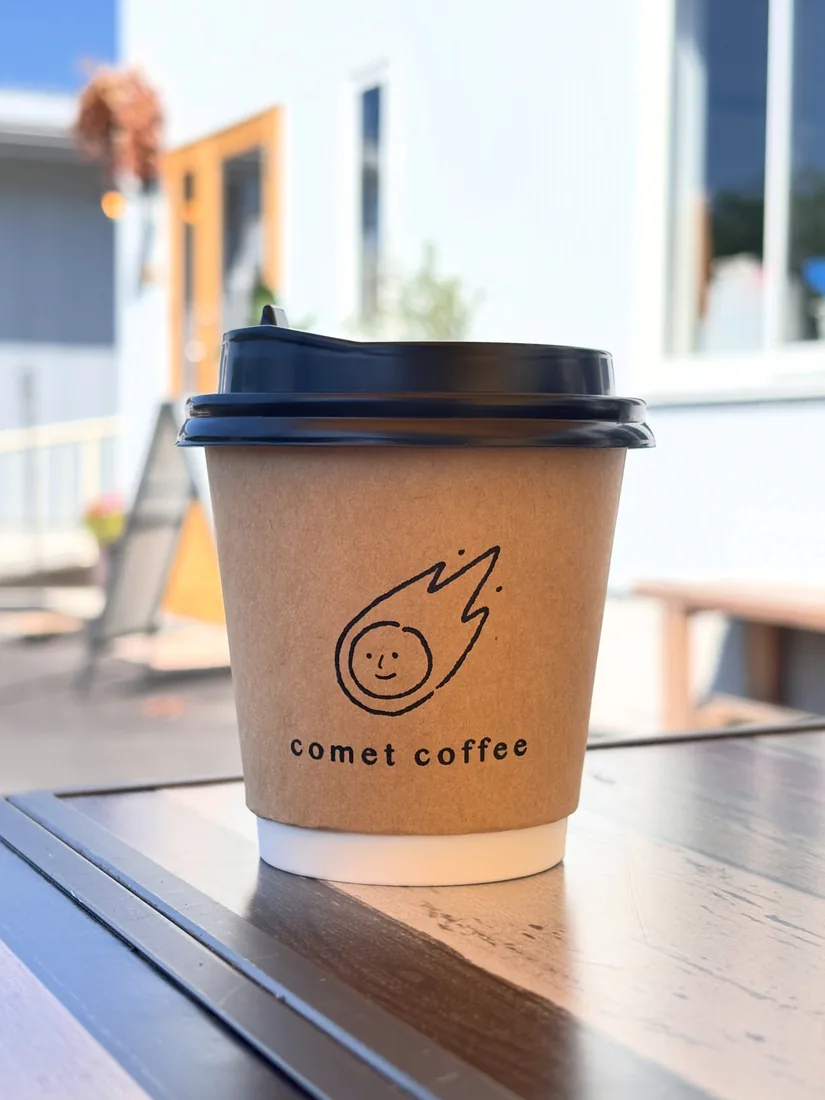 Comet Coffee のロゴが入ったテイクアウトカップ。瑞浪の店先のテーブルに置かれている